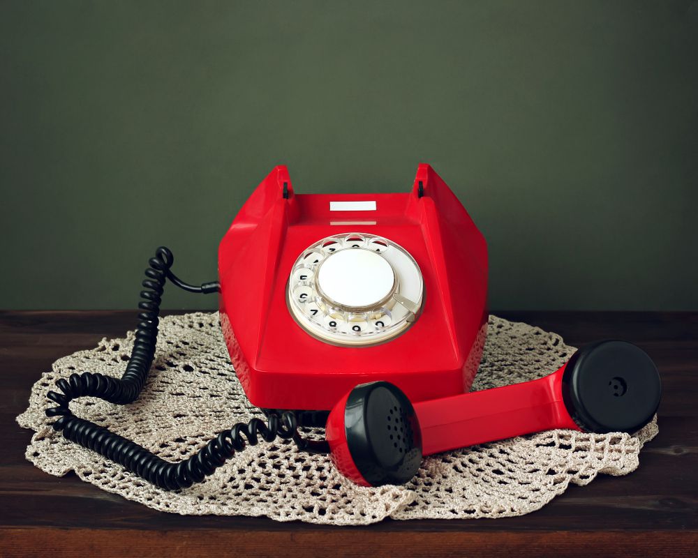 red-retro-rotary-phone-with-picked-up-receiver-lacy-napkin